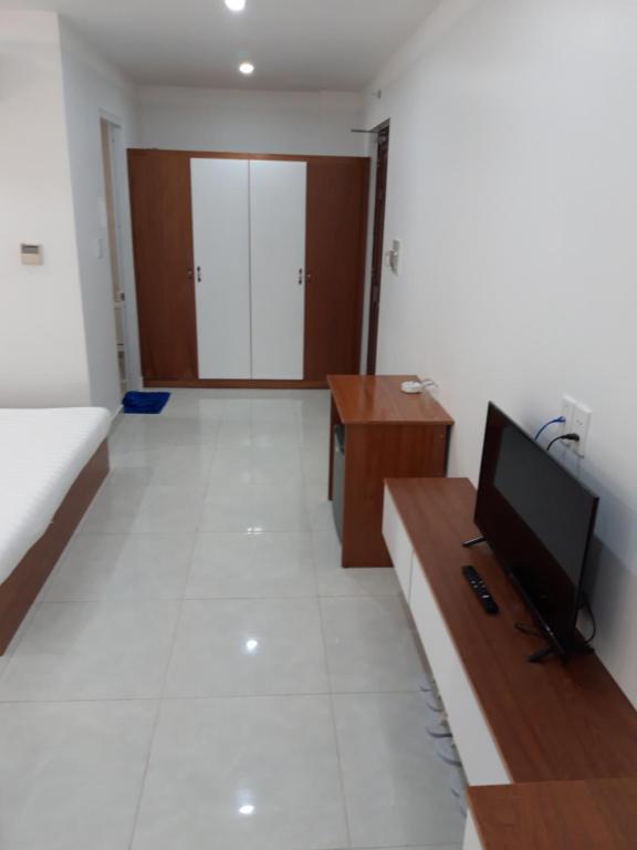 a living room with a flat screen tv and a desk at Sao Kim in Cà Mau