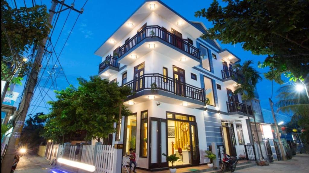 a white house with lights on it at Quynh Chau Homestay Hội An in Hoi An