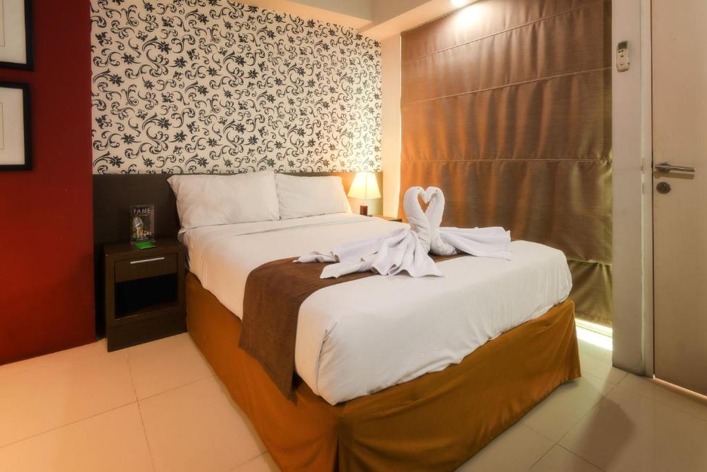 Postel nebo postele na pokoji v ubytování The Square Surabaya Hotel