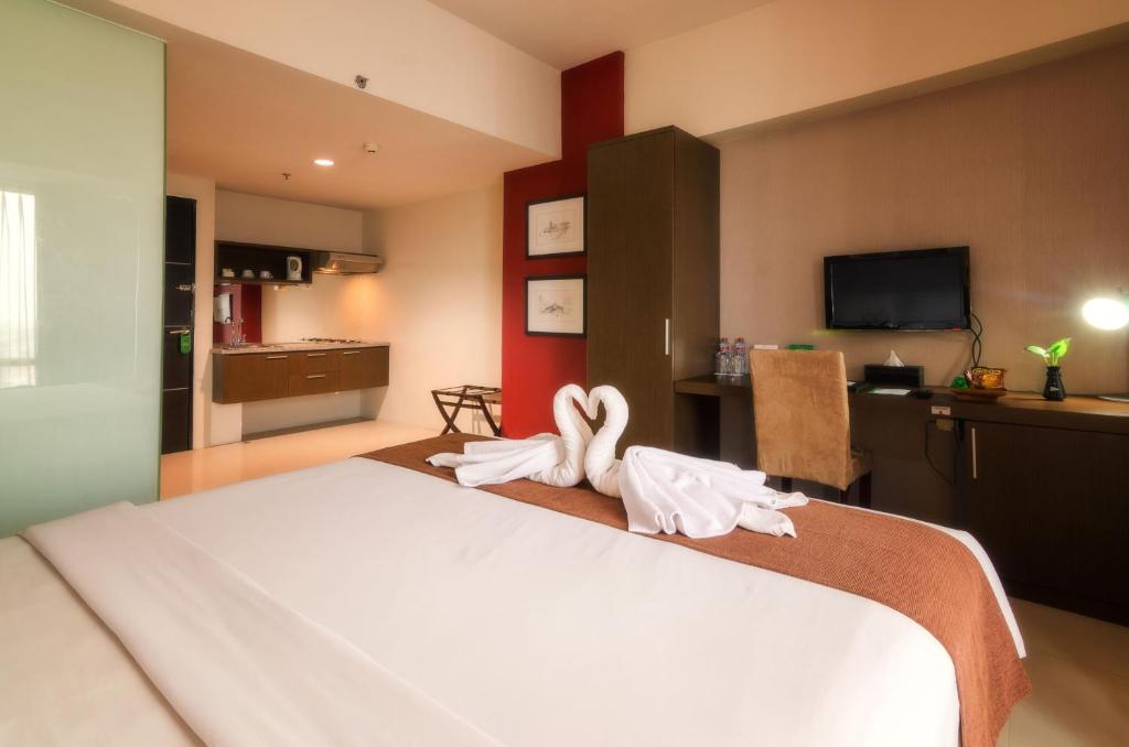 Postel nebo postele na pokoji v ubytování The Square Surabaya Hotel