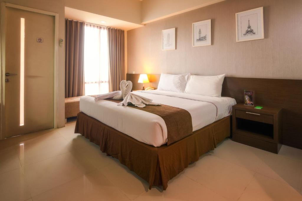 Postel nebo postele na pokoji v ubytování The Square Surabaya Hotel