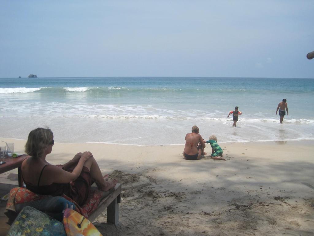 a group of people sitting on the beach at JJ Beach Resort & JJ Seafood in Ko Phayam