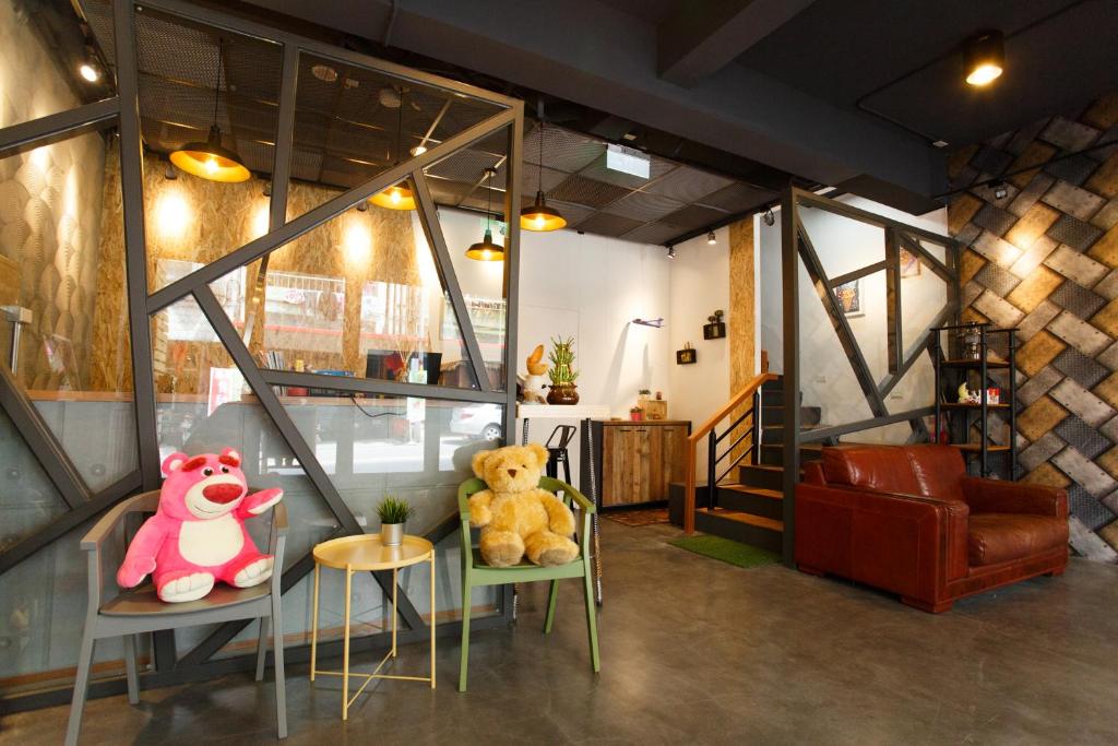 two teddy bears sitting on chairs in a room at Meng Yun Ge Hotel in Jiaoxi