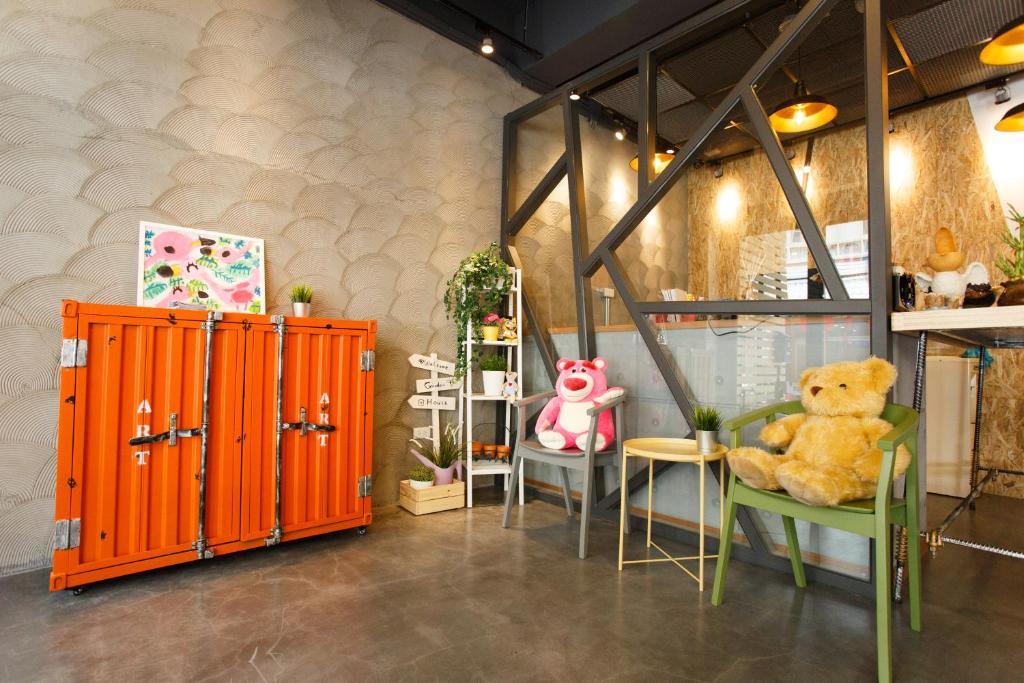 a teddy bear sitting in a green chair in a room at Meng Yun Ge Hotel in Jiaoxi