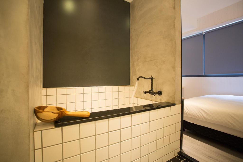 a small bathroom with a sink and a bed at Meng Yun Ge Hotel in Jiaoxi