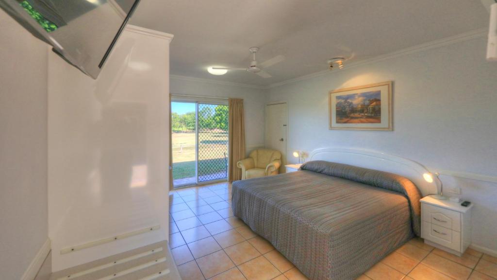 a bedroom with a bed and a balcony at Heritage Lodge Motel in Charters Towers