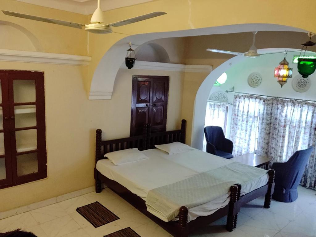 1 dormitorio con 1 cama, mesa y sillas en Natraj Guest House, en Ajmer