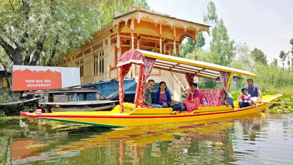 un grupo de personas montando en un barco en el agua en New Bul Bul Group of Houseboats Srinagar, en Srinagar
