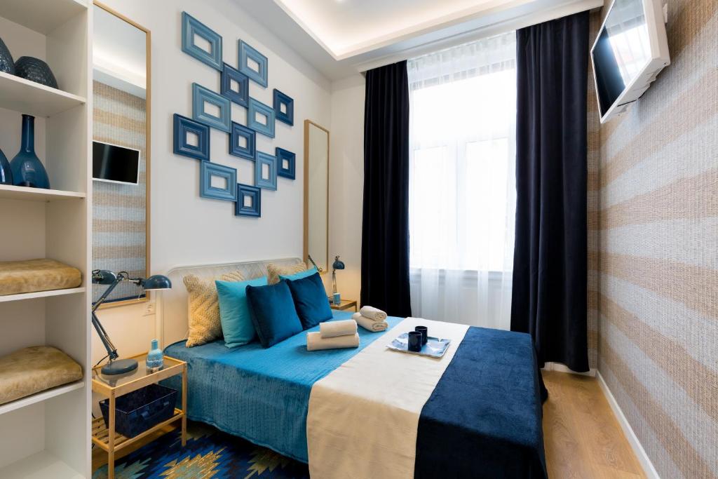 a bedroom with a blue bed and a window at Budapest Holidays Residence in Budapest