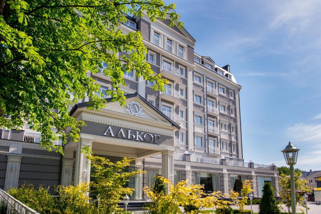 a large white building with a akiko sign on it at Hotel Alkor in Truskavets