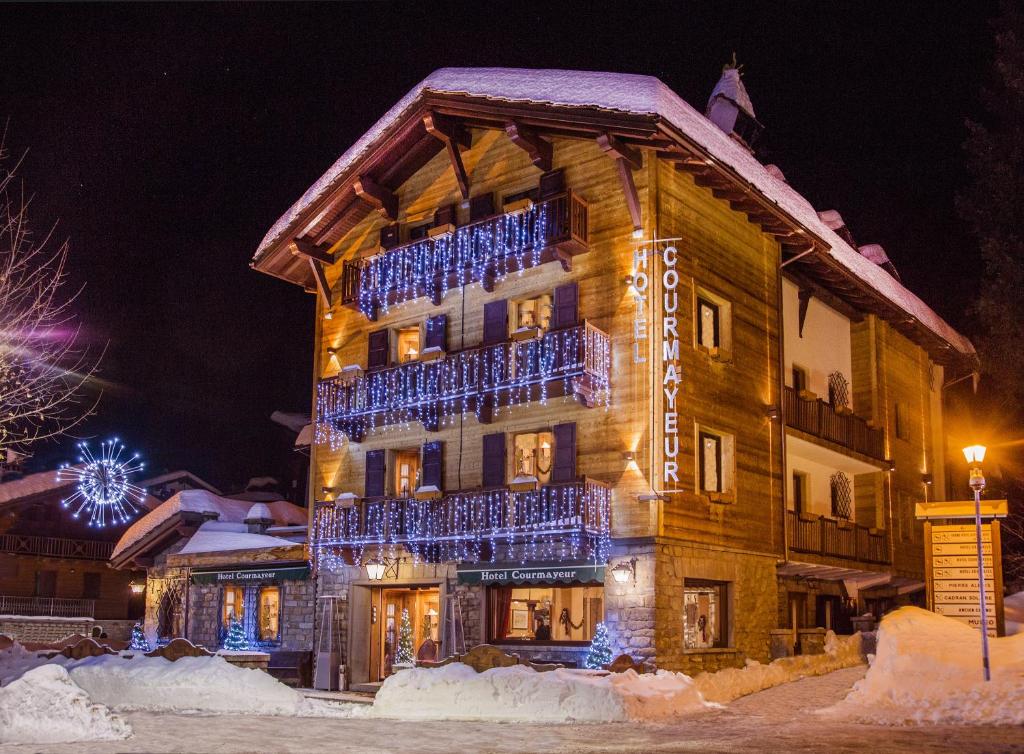 hotel w śniegu w nocy z niebieskimi światłami w obiekcie Hotel Courmayeur w mieście Courmayeur