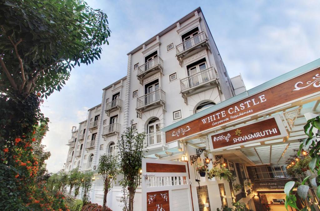 a white building with balconies on a street at White Castle Boutique Apartment Hotel in Bangalore