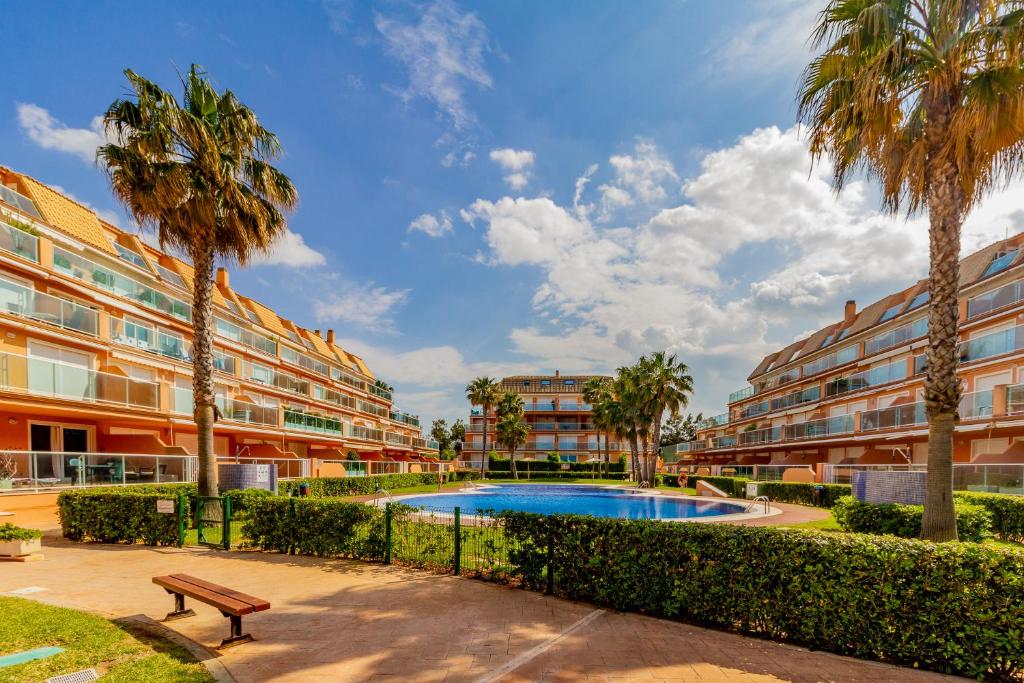 an apartment complex with a swimming pool and palm trees at RealRent Mirador al Mar in Denia