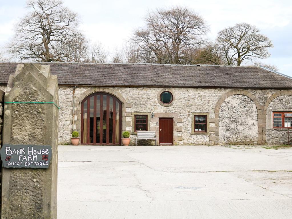 un bâtiment en pierre avec un panneau en face de celui-ci dans l'établissement Number 3, à Hartington