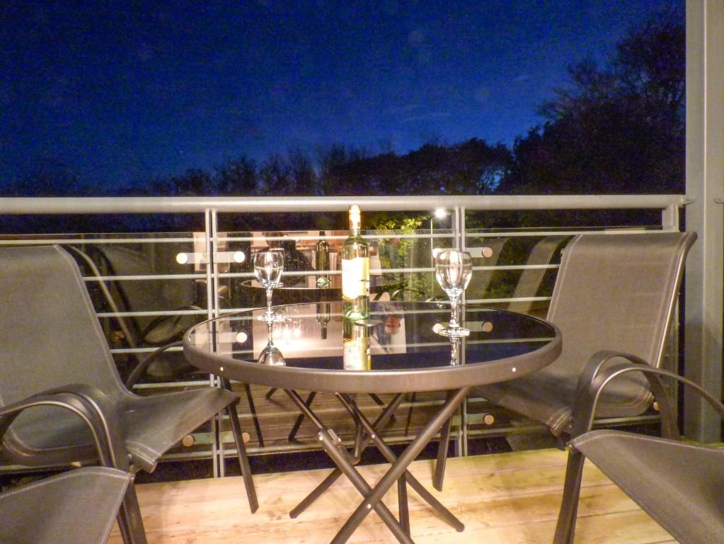 a table on a balcony with chairs and wine glasses at Tyack in Charlestown
