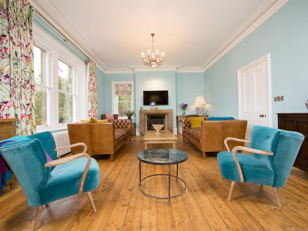 a living room with blue chairs and a table at Queen Ann's Close in Chinley