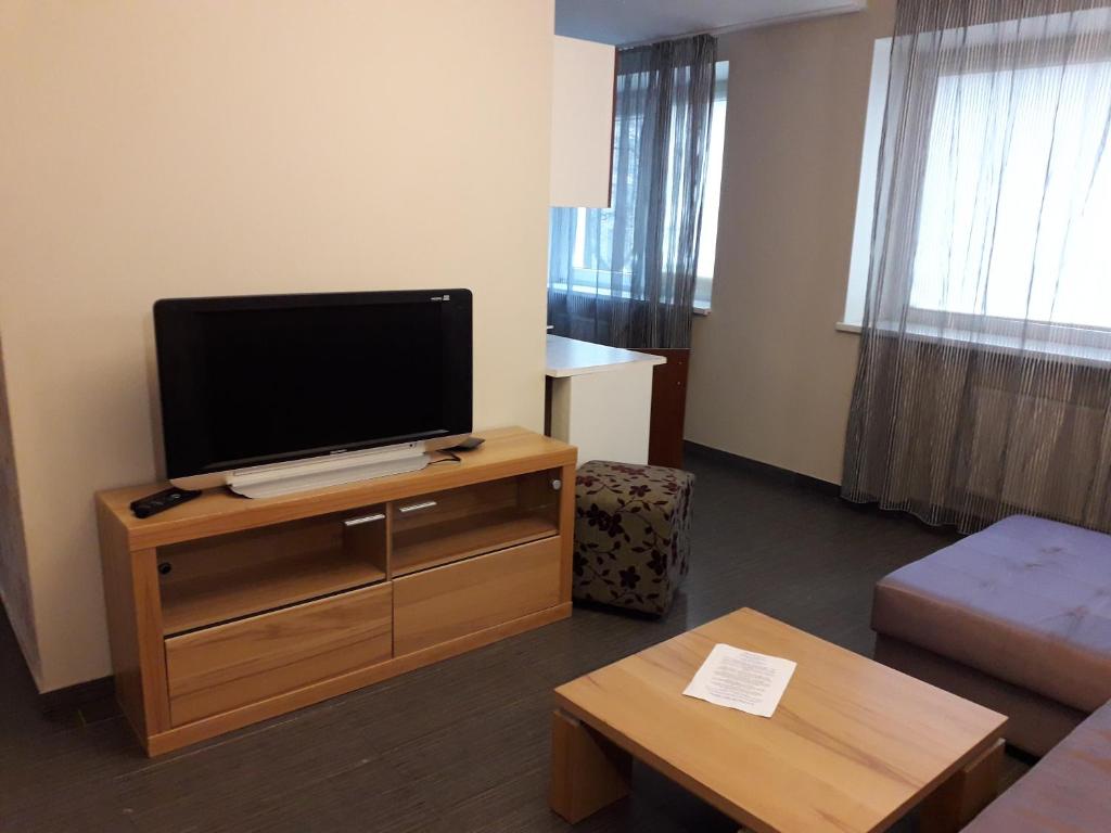 una sala de estar con un televisor de pantalla plana sobre un mueble en Laisves al. 7, en Kaunas