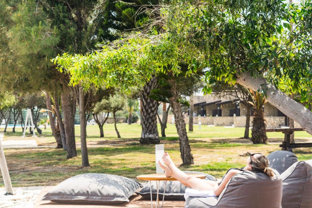 a woman laying on a couch in a park at Elya Beach Luxury Suites in Ayios Theodhoros