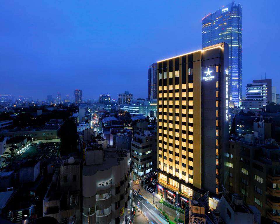 un edificio iluminado en una ciudad por la noche en Candeo Hotels Tokyo Roppongi en Tokio