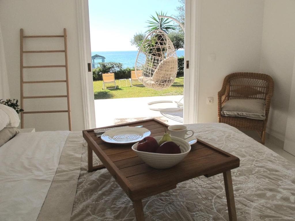 a table with a bowl of fruit on a bed at Aqua Seafront Glyfada Corfu Beach House With Garden in Glyfada