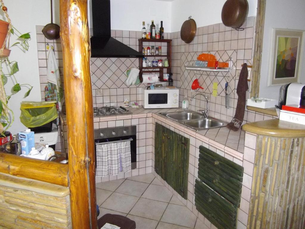 uma pequena cozinha com um lavatório e um micro-ondas em Casa S'Arriali em Iglesias