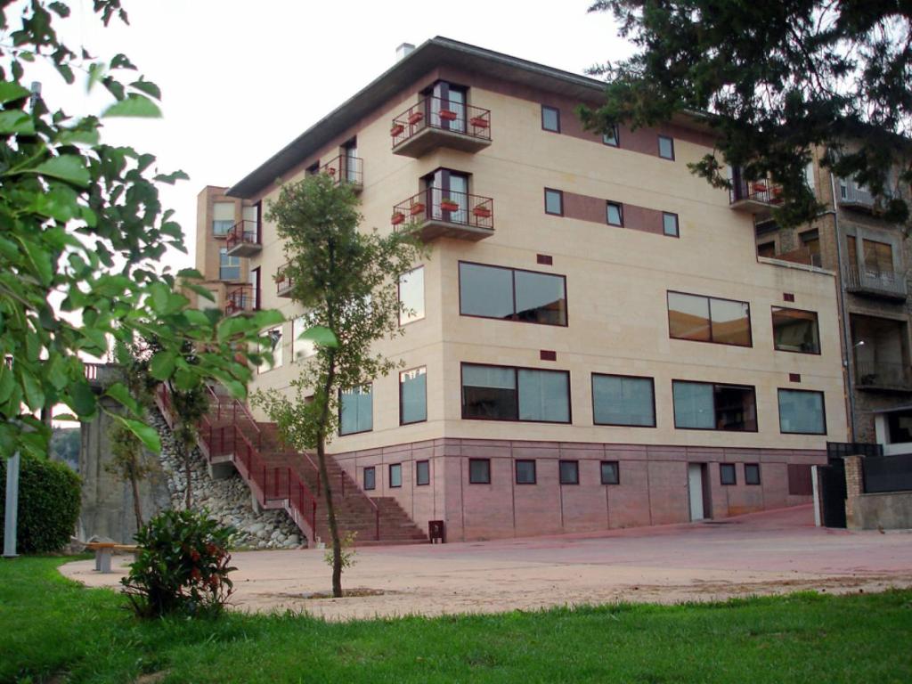 an apartment building with stairs in front of it at Hotel Sant Quirze De Besora in Sant Quirze de Besora