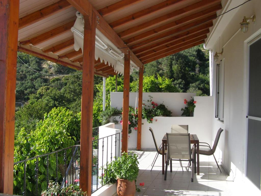 un patio con tavolo e sedie sul balcone. di Aerinos House a Aërinós