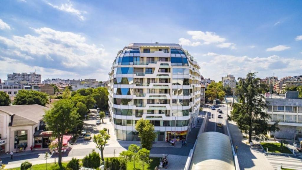 ブルガスにあるSuper Central Luxury Apartmentsの通り付きの都市の白い高い建物