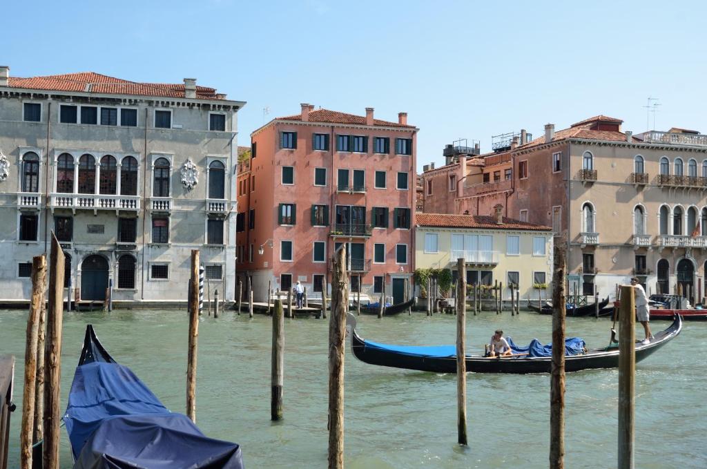 a gondola in the water in front of buildings at Charming Apartment On Grand Canal in Venice
