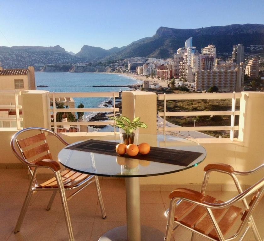 a table on a balcony with a view of the ocean at Rubino in Calpe