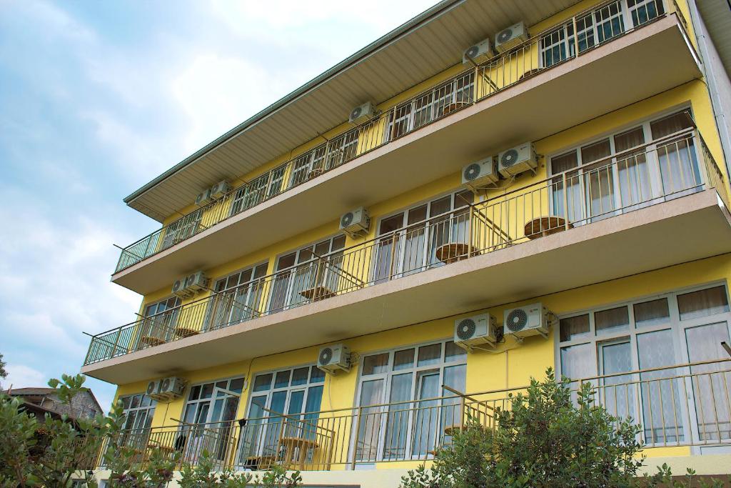 アドレルにあるAida Guest Houseの黄色の建物(バルコニー付)