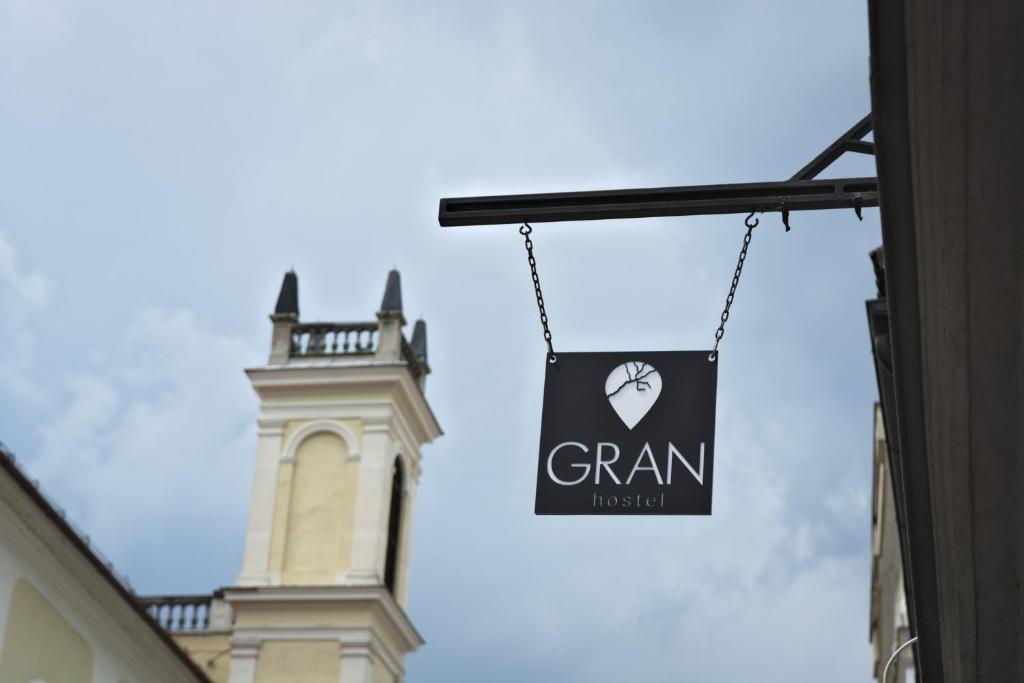 a sign hanging from a building in front of a tower at GRAN hostel in Banská Bystrica