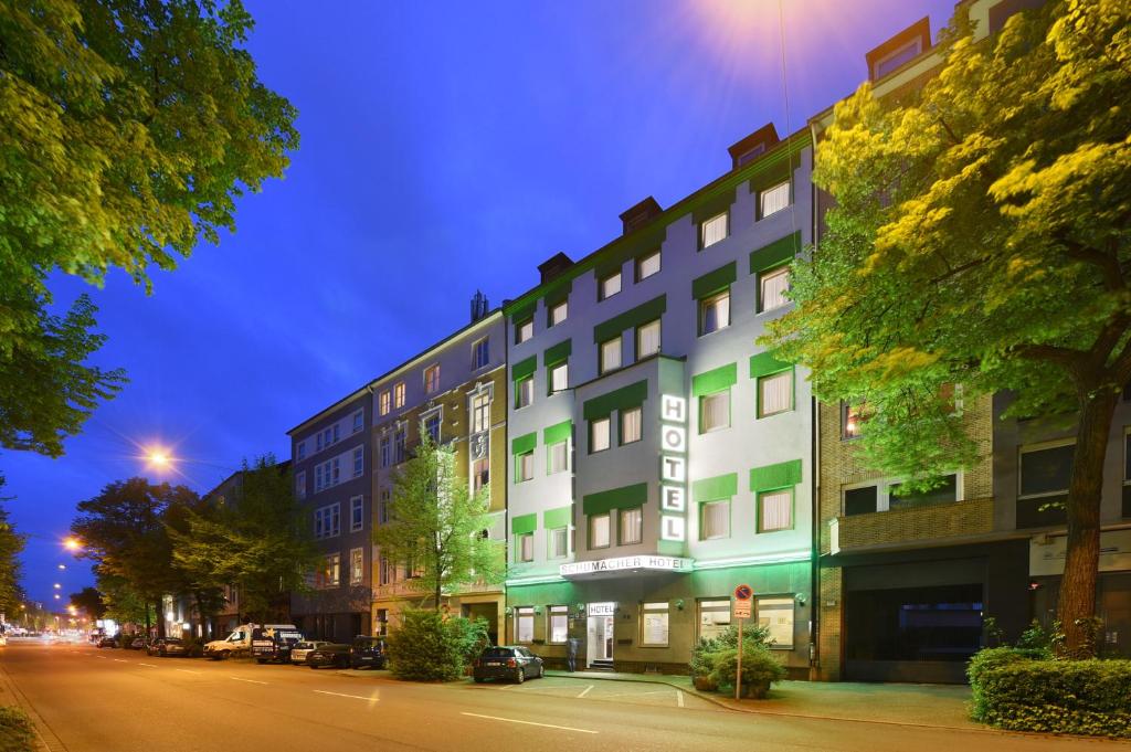 a large building on a city street at night at Hotel Schumacher Düsseldorf in Düsseldorf