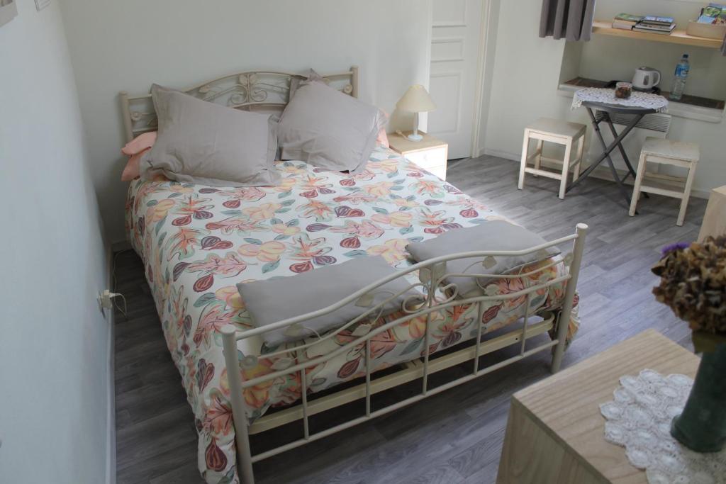 a bedroom with a bed with a floral comforter at Dans un écrin de Nature in Montclar