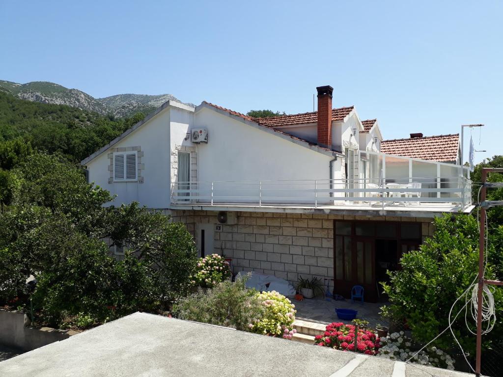 uma casa branca com uma varanda em cima em Apartment Ivana em Viganj