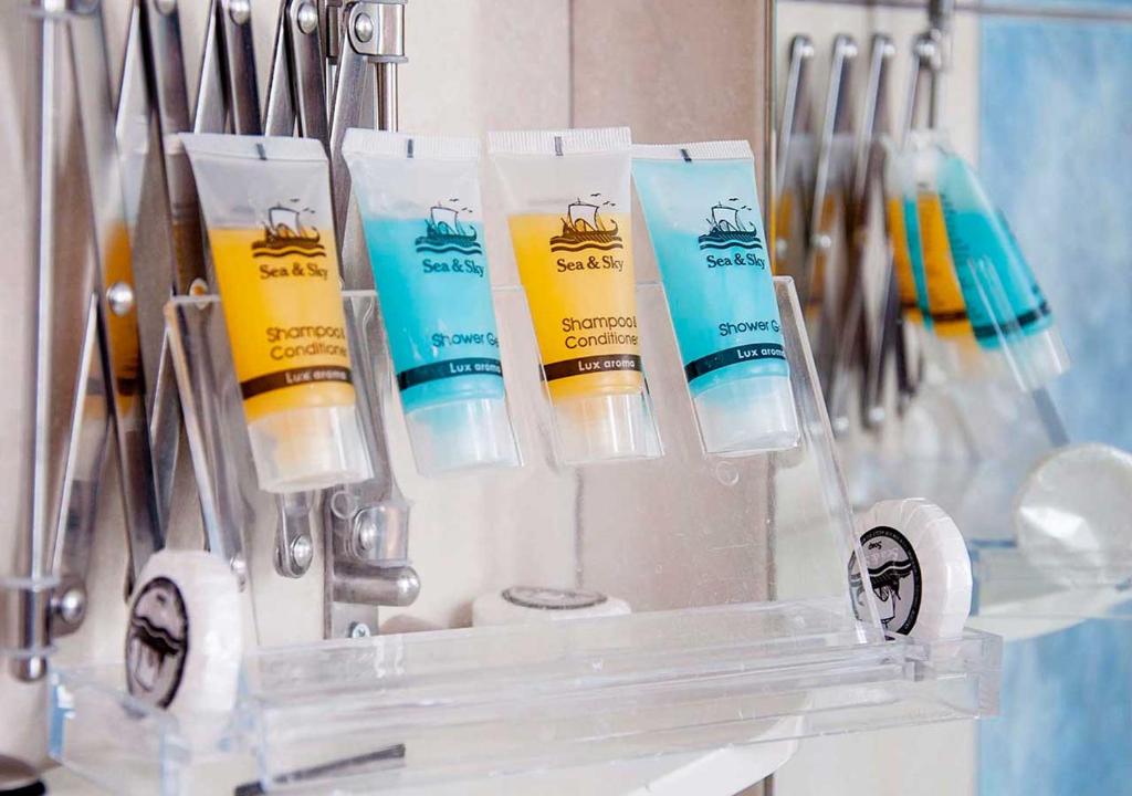a group of four bottles of sunscreen in a room at Stefanakis Hotel & Apartments in Varkiza