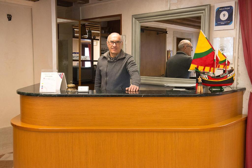 a man standing at a counter in a salon at Domus Clugiae in Chioggia