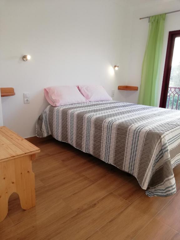 a bedroom with a bed with a striped blanket at Sol Mar in Odeceixe