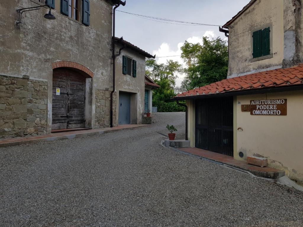 une rue vide dans un vieux bâtiment avec garage dans l'établissement Agriturismo Podere Omomorto, à Pratovecchio