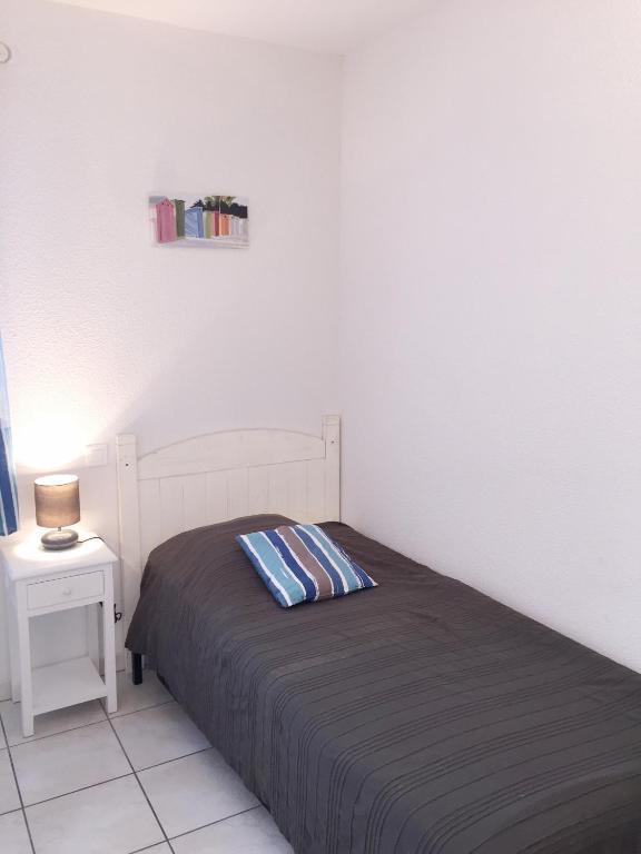 a bedroom with a bed and a table with a lamp at Residence Plage Oceane in Biscarrosse-Plage