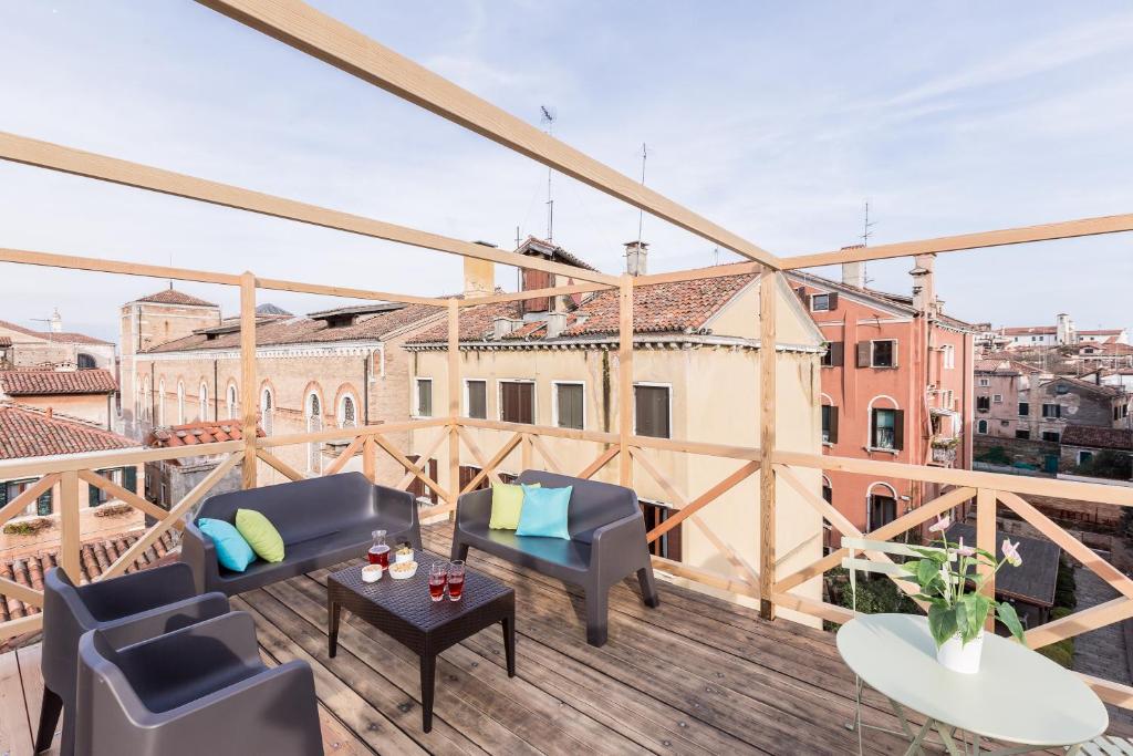- un balcon avec des canapés et des tables dans un bâtiment dans l'établissement Ca' del Monastero 7 Collection Bright Apartment with Terrace, à Venise