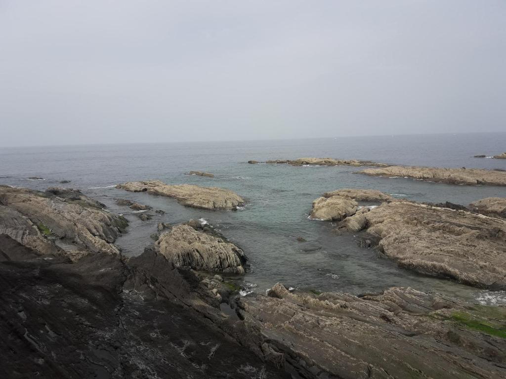 un grupo de rocas en el océano cerca del agua en Apartamento Ondarroa, en Ondárroa