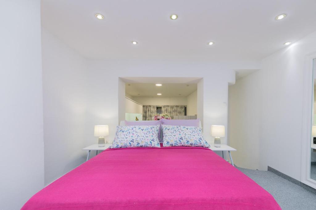 ein Schlafzimmer mit einem rosa Bett mit zwei Kissen in der Unterkunft Peninsula room in Zadar