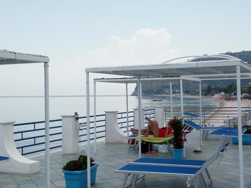una terraza con sillas y mesas en un barco en B&B Conca del Faro en Mattinata
