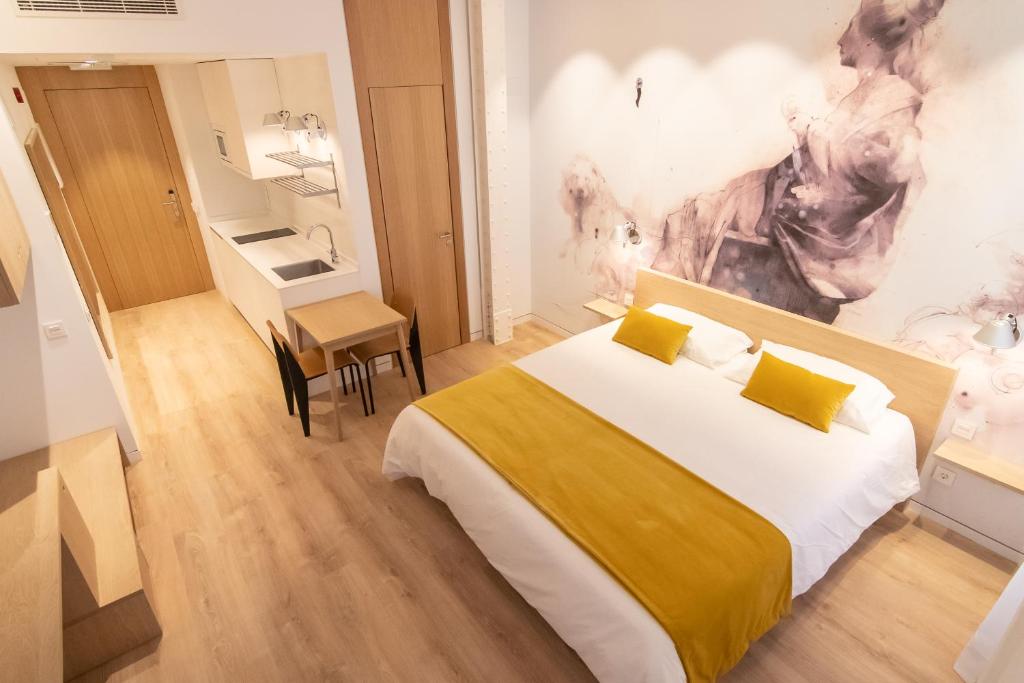 um quarto com uma cama grande e uma secretária em Plaza Mayor Suites & Apartments em Madri