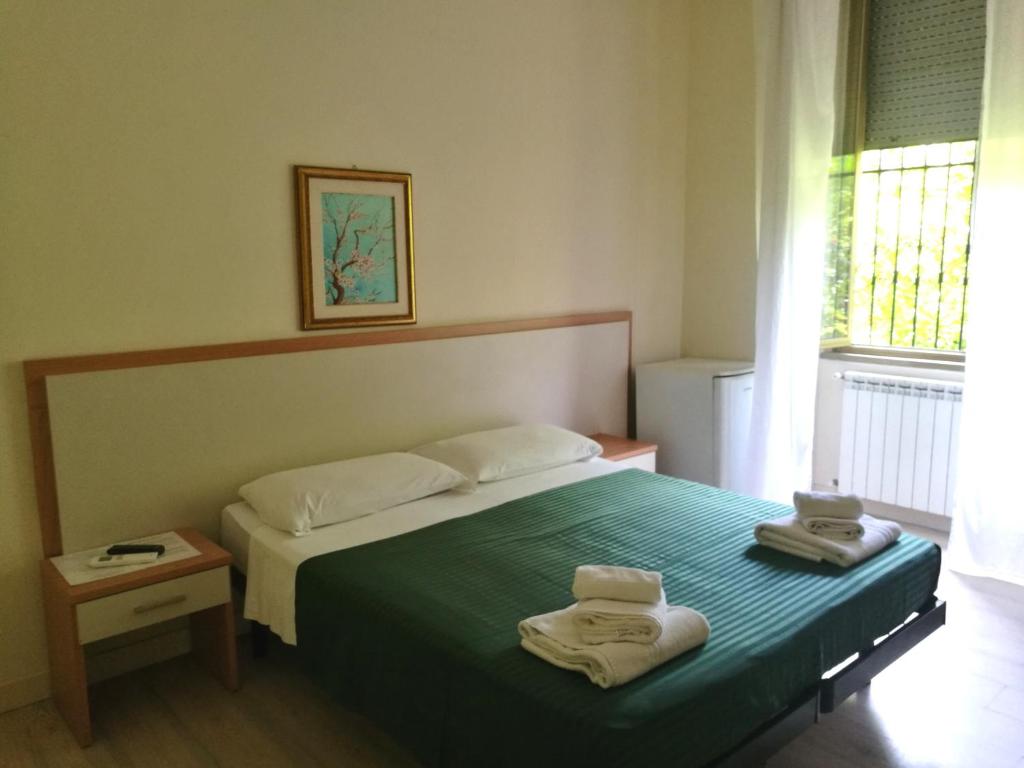 a bedroom with a bed with two towels on it at In Rome in Rome