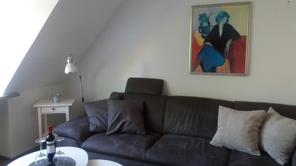ein Wohnzimmer mit einem braunen Sofa und einem Gemälde in der Unterkunft Ferienwohnung Brunnenstrasse in Bremervörde
