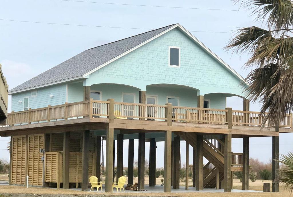 a house with a wrap around deck on the beach at Lisa'S Landing Home in Bolivar Peninsula