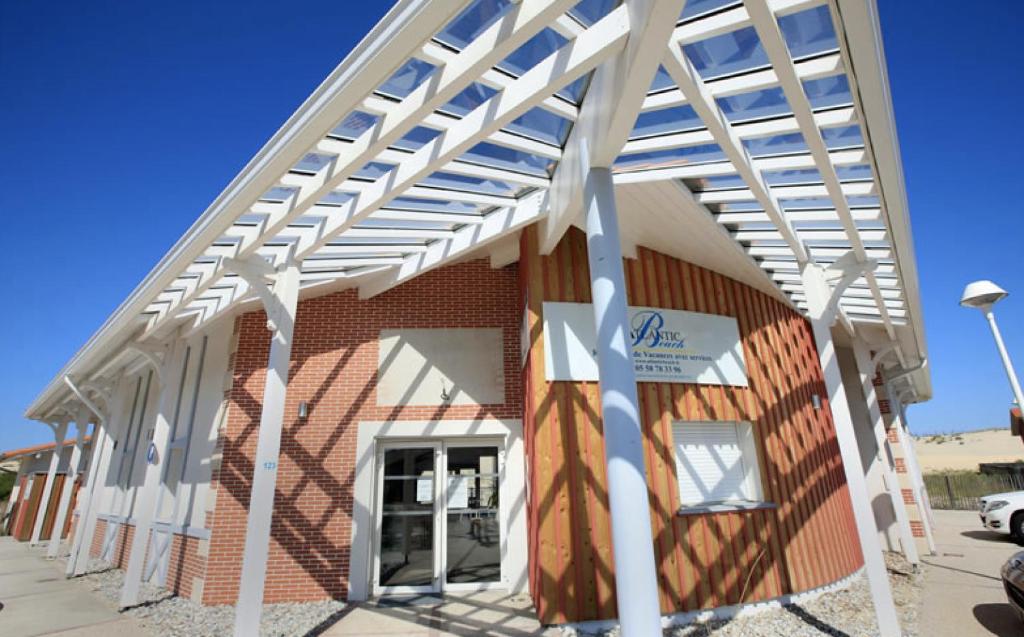 a white pergola on the side of a building at Residence Plage Oceane in Biscarrosse-Plage