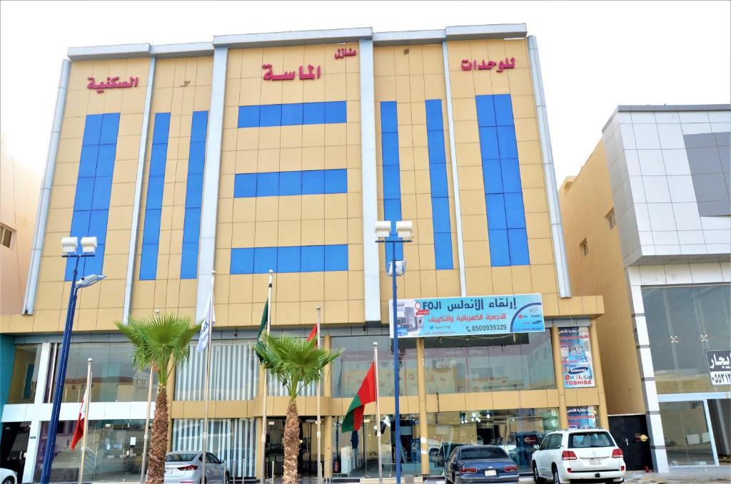 ein großes Gebäude mit davor geparkt in der Unterkunft منـازل الماسة للشقق المخدومة بريدة in Buraida